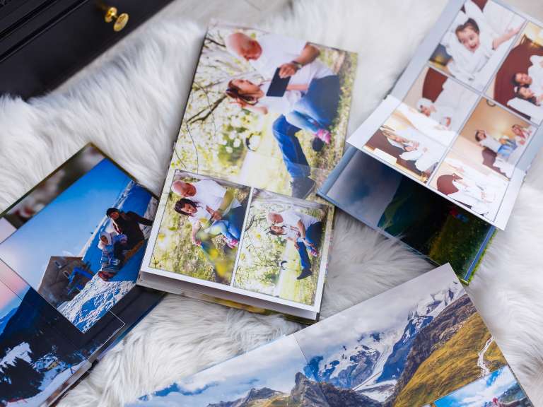 Fotoalben liegen geöffnet auf einem weißen Teppichboden