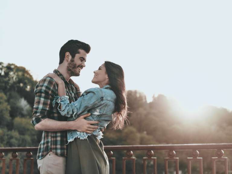 Paar umarmt sich und schaut sich in die Augen bei Sonnenuntergang