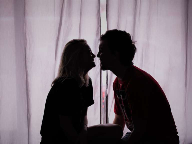 Paar sitzt sich gegenüber und schaut sich lächelnd an