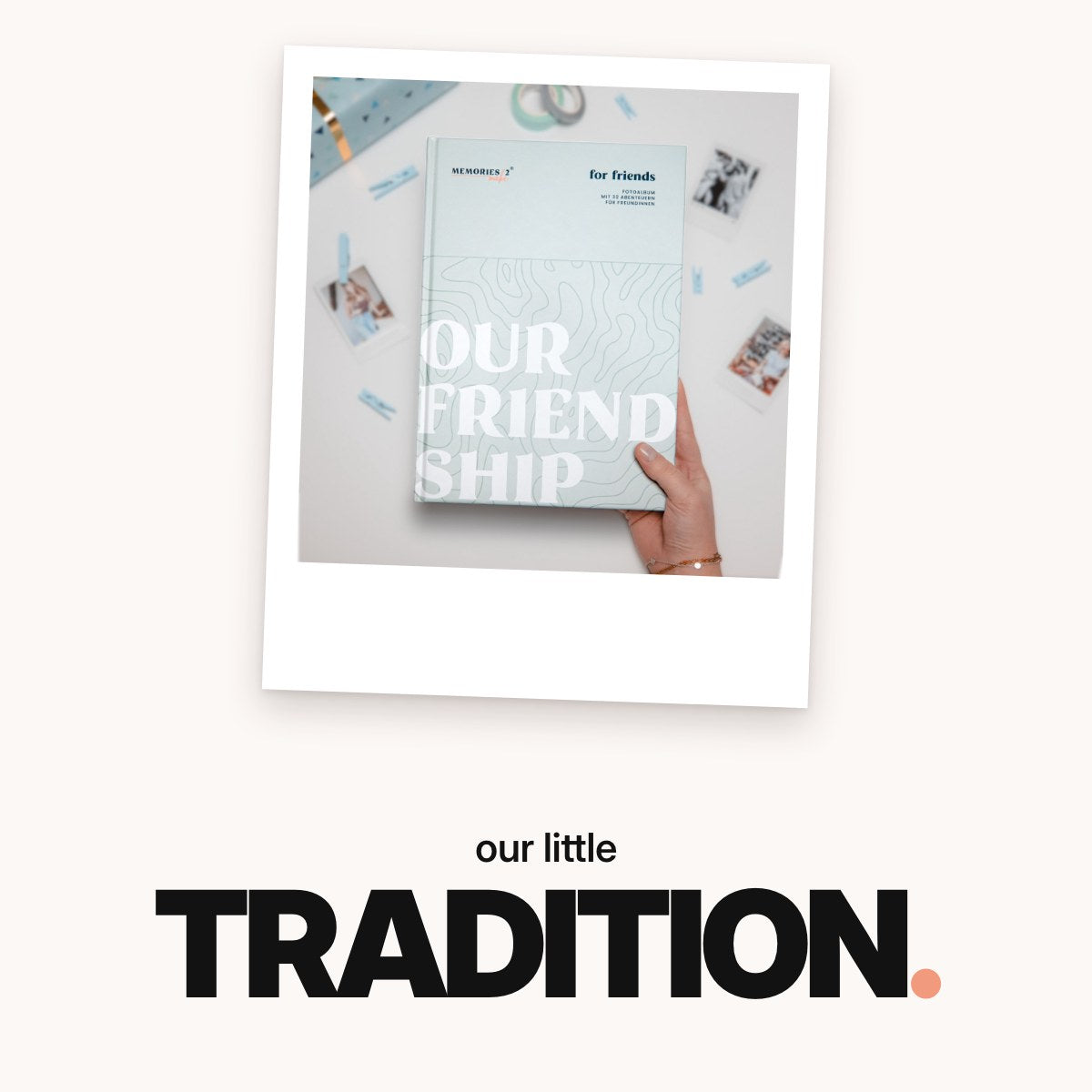 Schriftzug ‚our little TRADITION.‘ über dem mintgrünen Challengebuch für beste Freundinnen in einer Hand, umgeben von Sofortbildfotos, Holzklammern, Washi-Tape und einem Geschenkpaket.