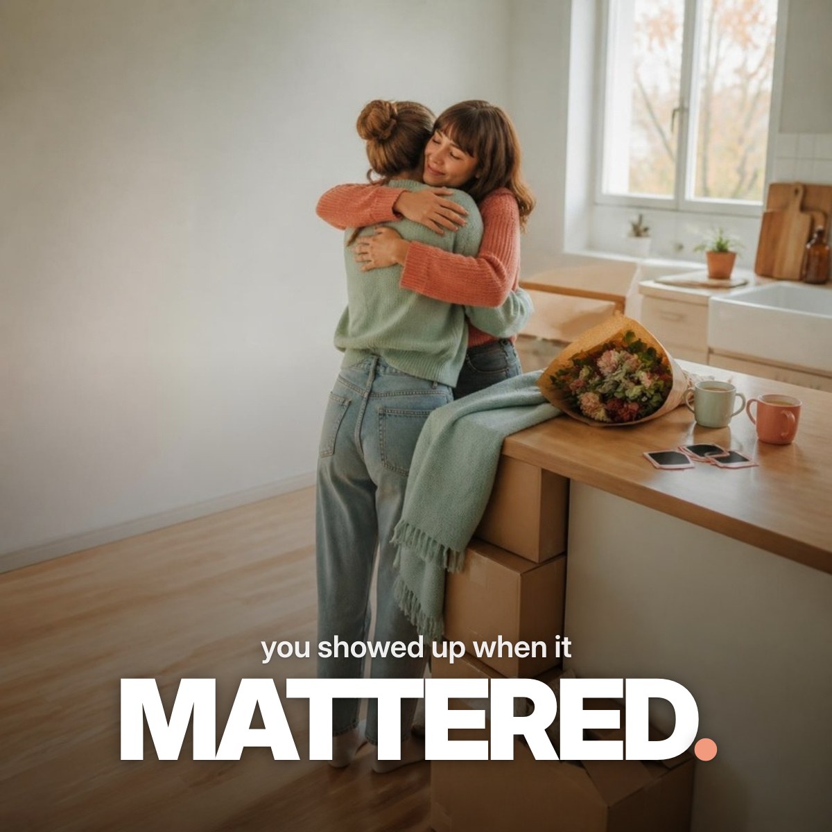 Schriftzug ‚you showed up when it MATTERED.‘ über einem Foto zweier Freundinnen, die sich in einer hellen Küche zwischen Umzugskartons umarmen, daneben Tee, Blumen und Sofortbilder.