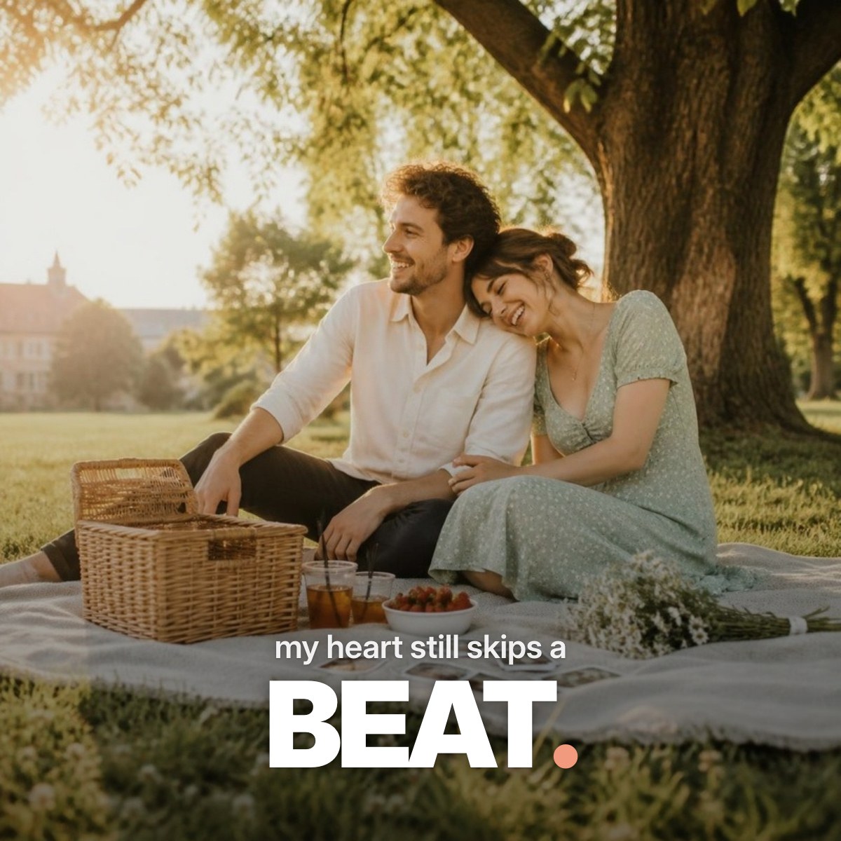 Schriftzug ‚my heart still skips a BEAT.‘ über einem Foto eines jungen Paares, das bei goldenem Abendlicht eng aneinandergelehnt auf einer Picknickdecke unter einem Baum im Park sitzt.