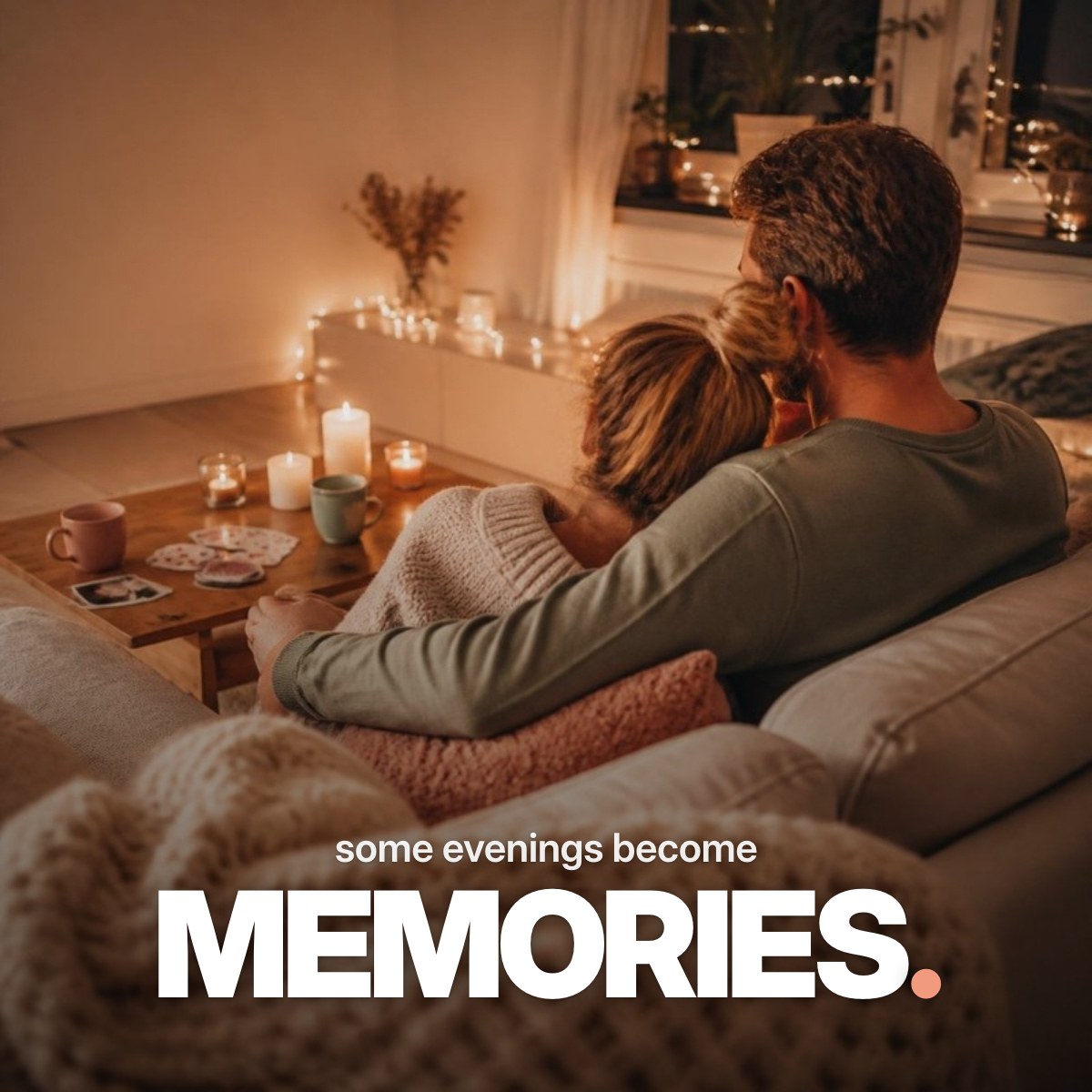 Schriftzug ‚some evenings become MEMORIES.‘ über einem Foto eines Paares, das von hinten gesehen eng aneinandergekuschelt auf einem Sofa bei Kerzen- und Lichterkettenschein sitzt, vor ihnen ein Tisch mit Karten, Tee und Sofortbildern.
