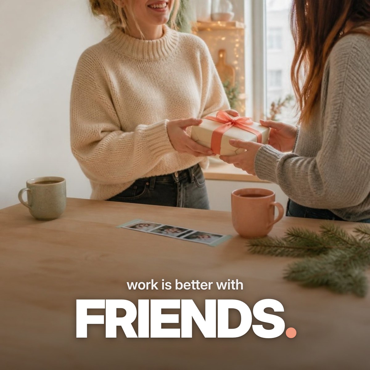 Schriftzug ‚work is better with FRIENDS.‘ über einem Foto, auf dem sich zwei Kolleginnen in einer weihnachtlich beleuchteten Büroküche ein kleines, in cremefarbenes Papier mit Korallschleife verpacktes Wichtelgeschenk überreichen.