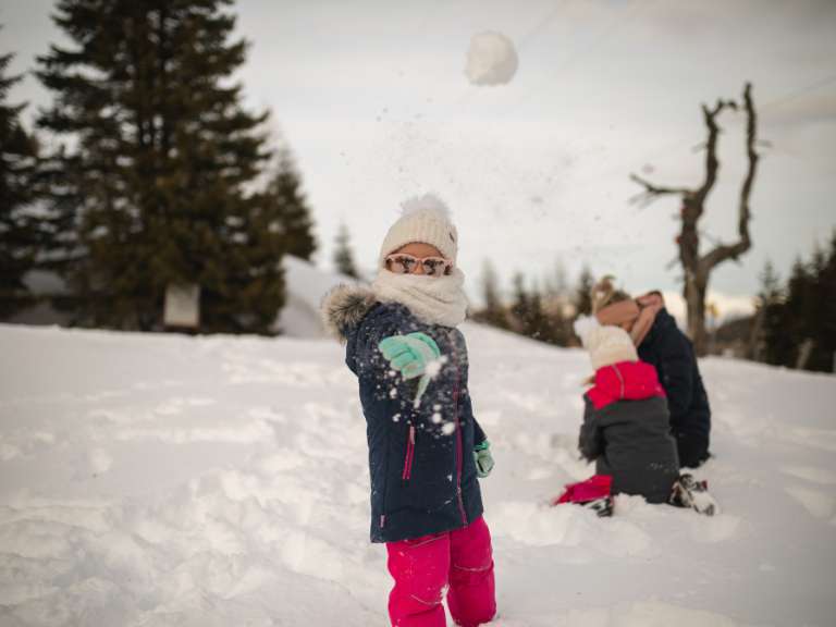 Kinder spielen im Schnee und formen Schneebälle