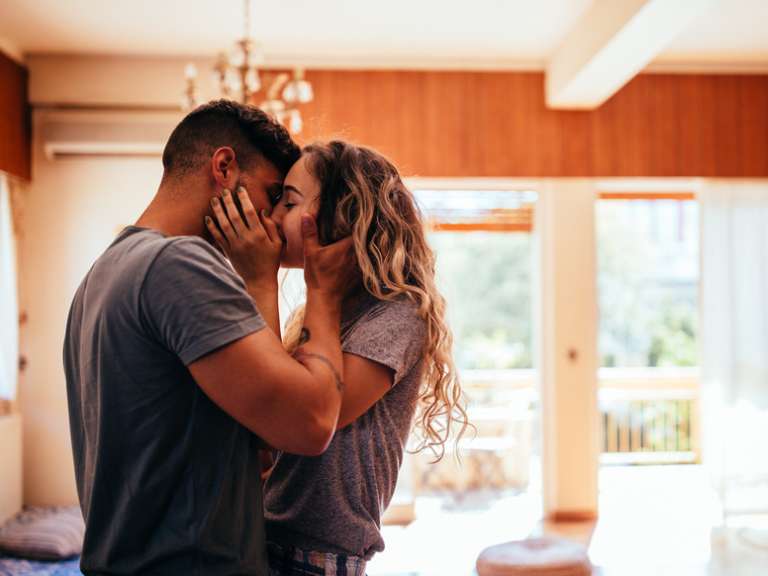 Junges Paar küsst sich innig und hält sich im Arm