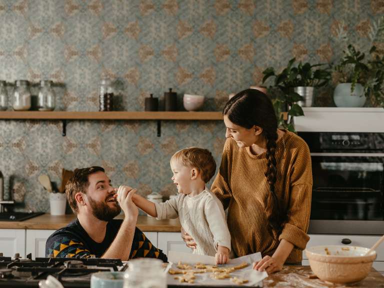 Junge Familie mit kleinem Junge steht in der Küche und kocht gemeinsam etwas