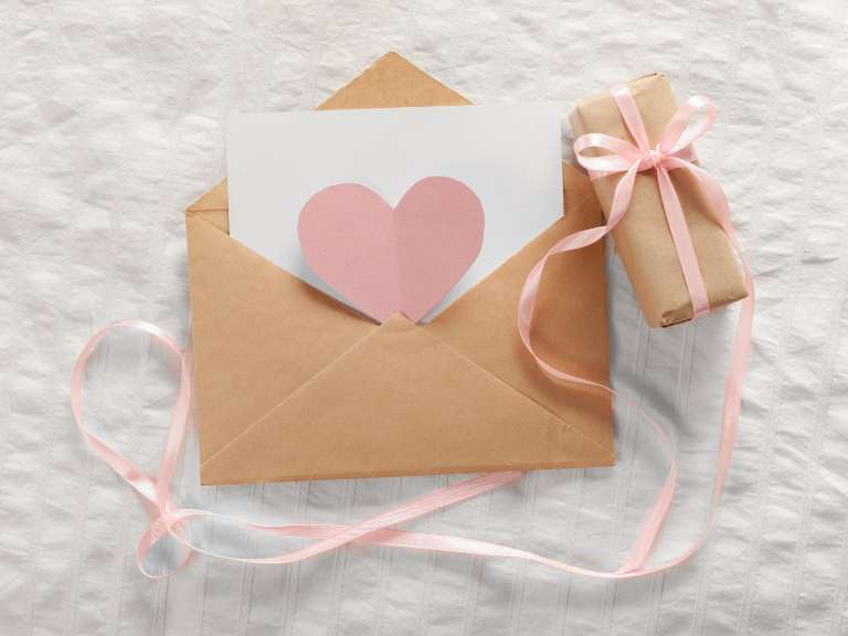 Liebesbrief liegt in einem Kuvert auf einer Decke