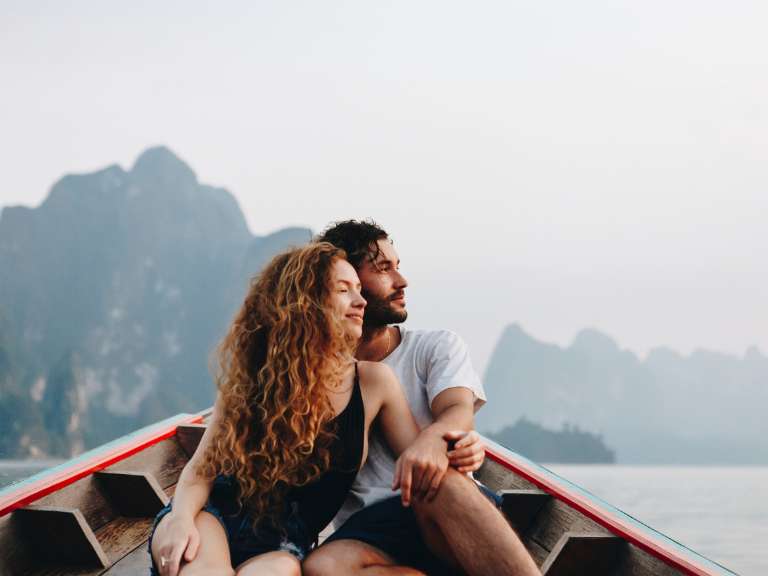 Junges Paar sitzt in einem Boot und genießt die Landschaft