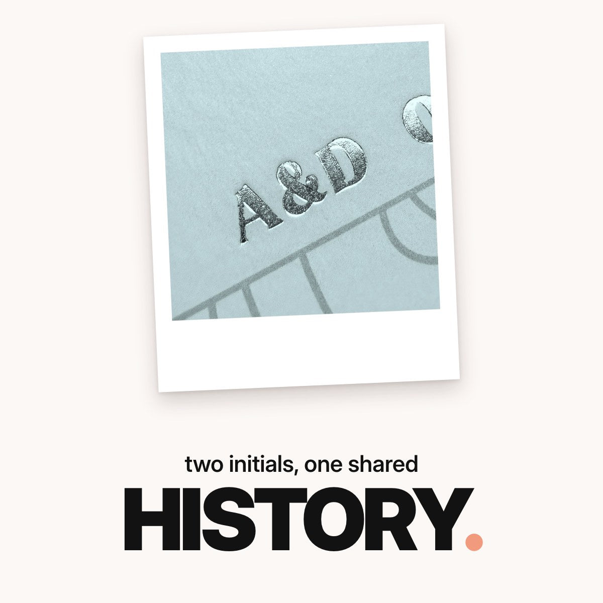 Schriftzug ‚two initials, one shared HISTORY.‘ über einer Makroaufnahme der silbernen Folienprägung mit den Initialen ‚A&D‘ auf dem mintgrünen Cover des Freundebuchs.